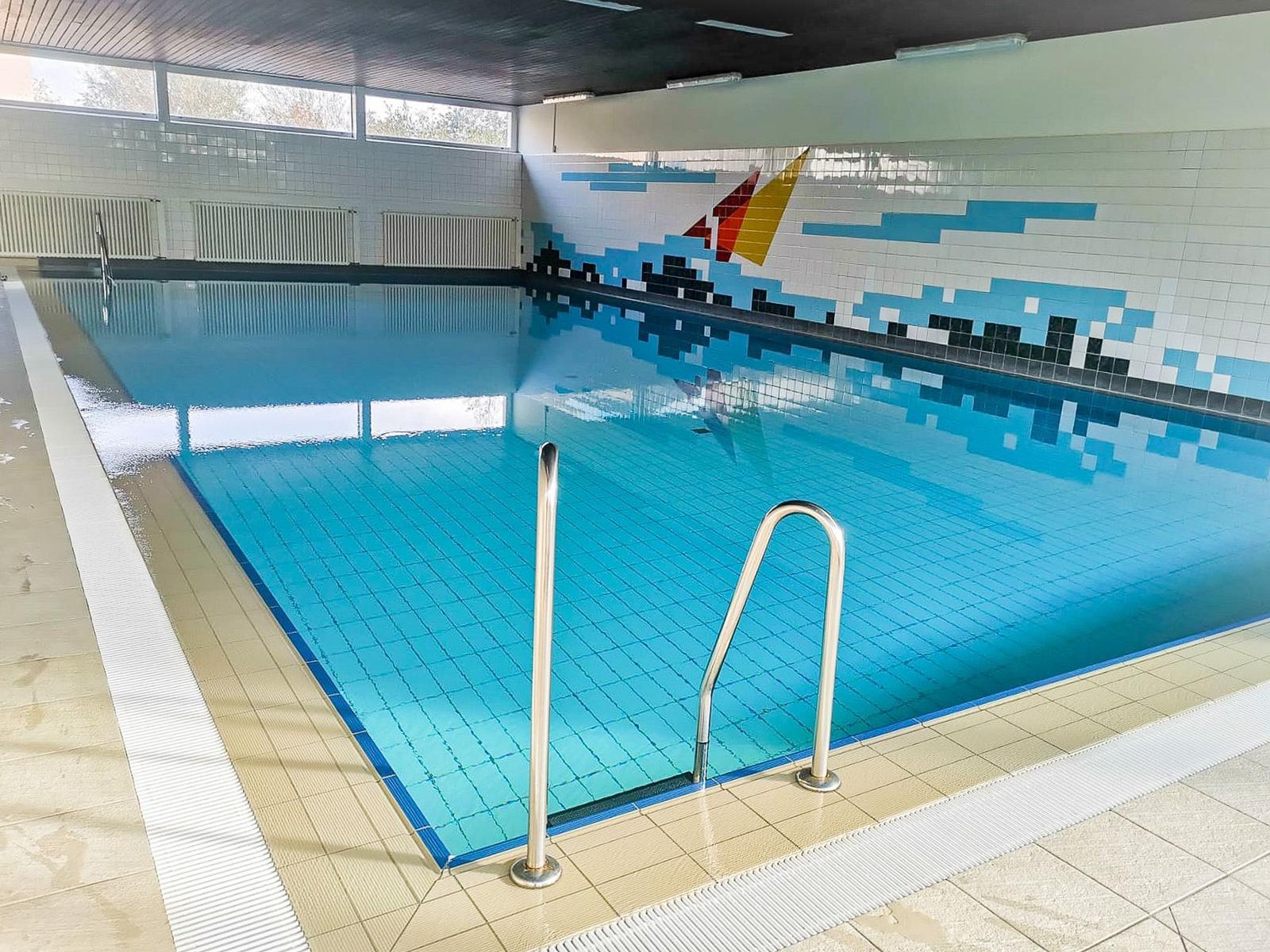 Innenpool mit Sprungbrett und Mosaikwand