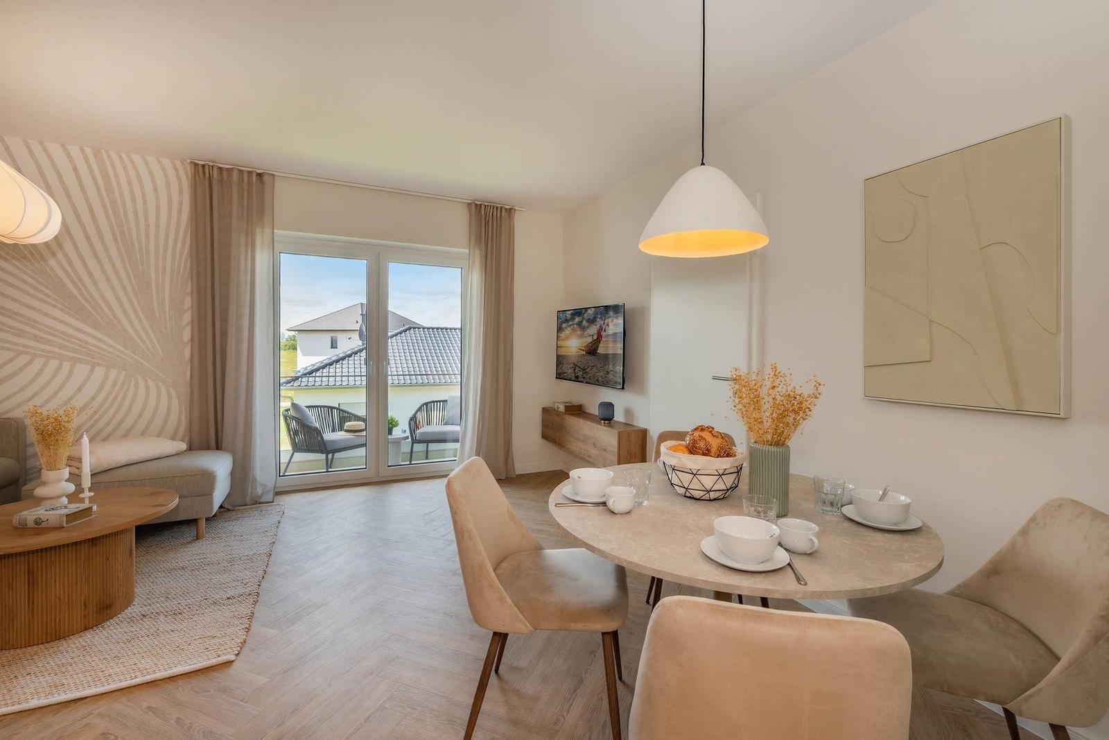 Essbereich mit runder Tisch und Stühlen, Wohnbereich mit Sofa und Balkonansicht.