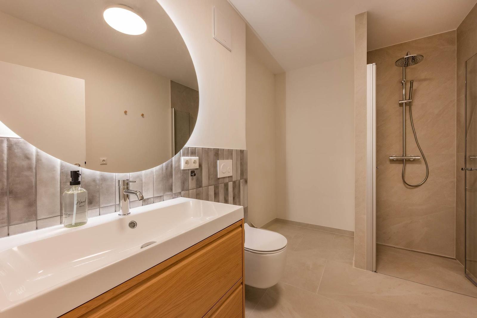 Badezimmer mit Dusche, Waschbecken und Toilette