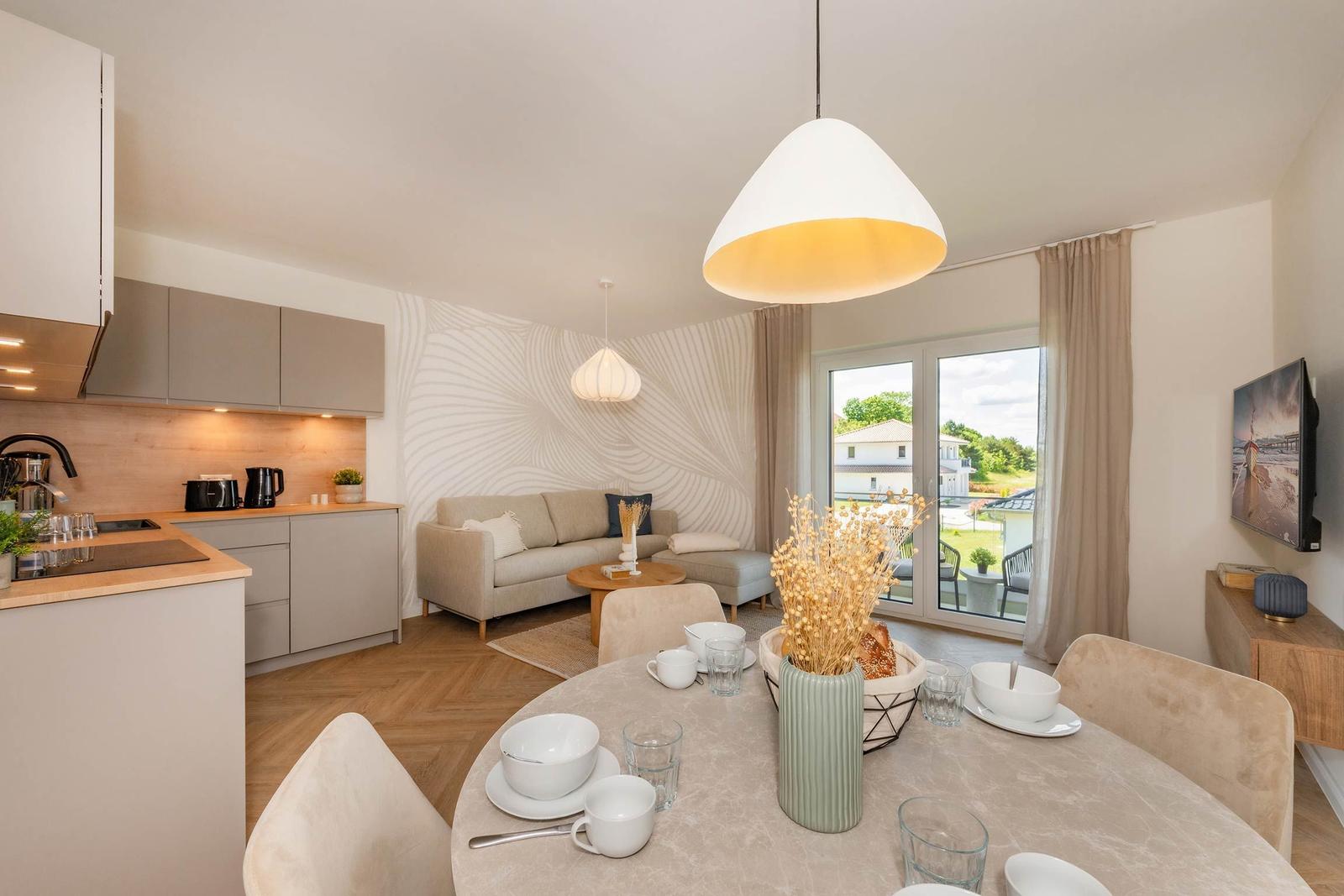 Wohnung mit Küche, Essbereich und Wohnzimmer mit Blick auf Garten.