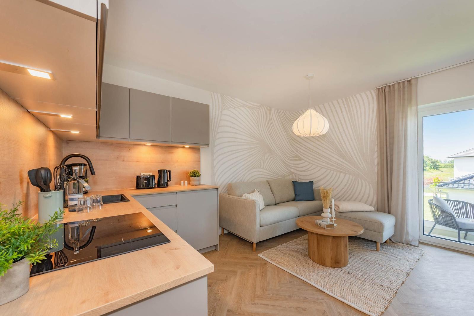 Küche mit Holzoberflächen und Wohnbereich mit Sofa und Couchtisch.