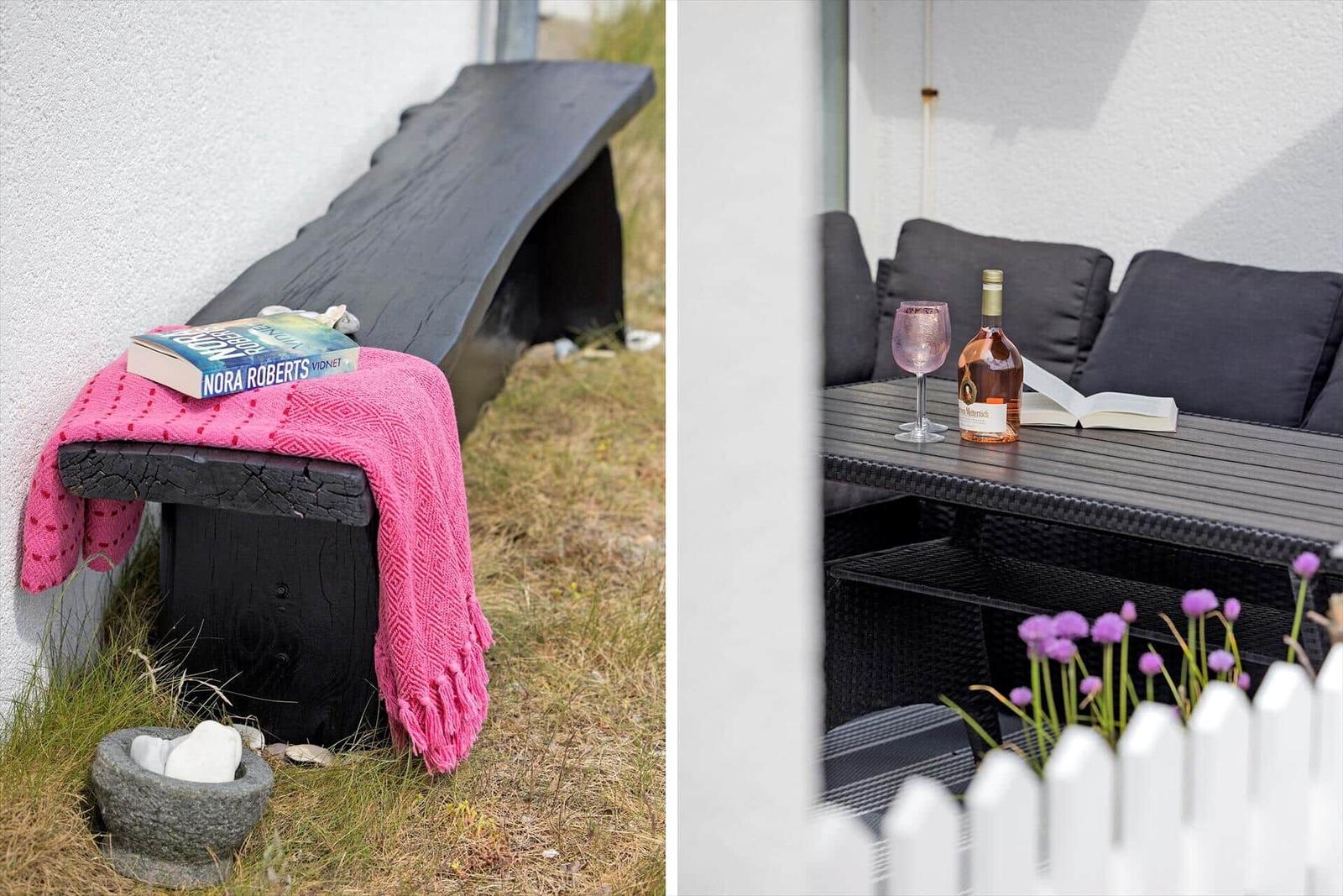 Outdoor area with bench, table, and seating. On the table is a bottle and a glass.