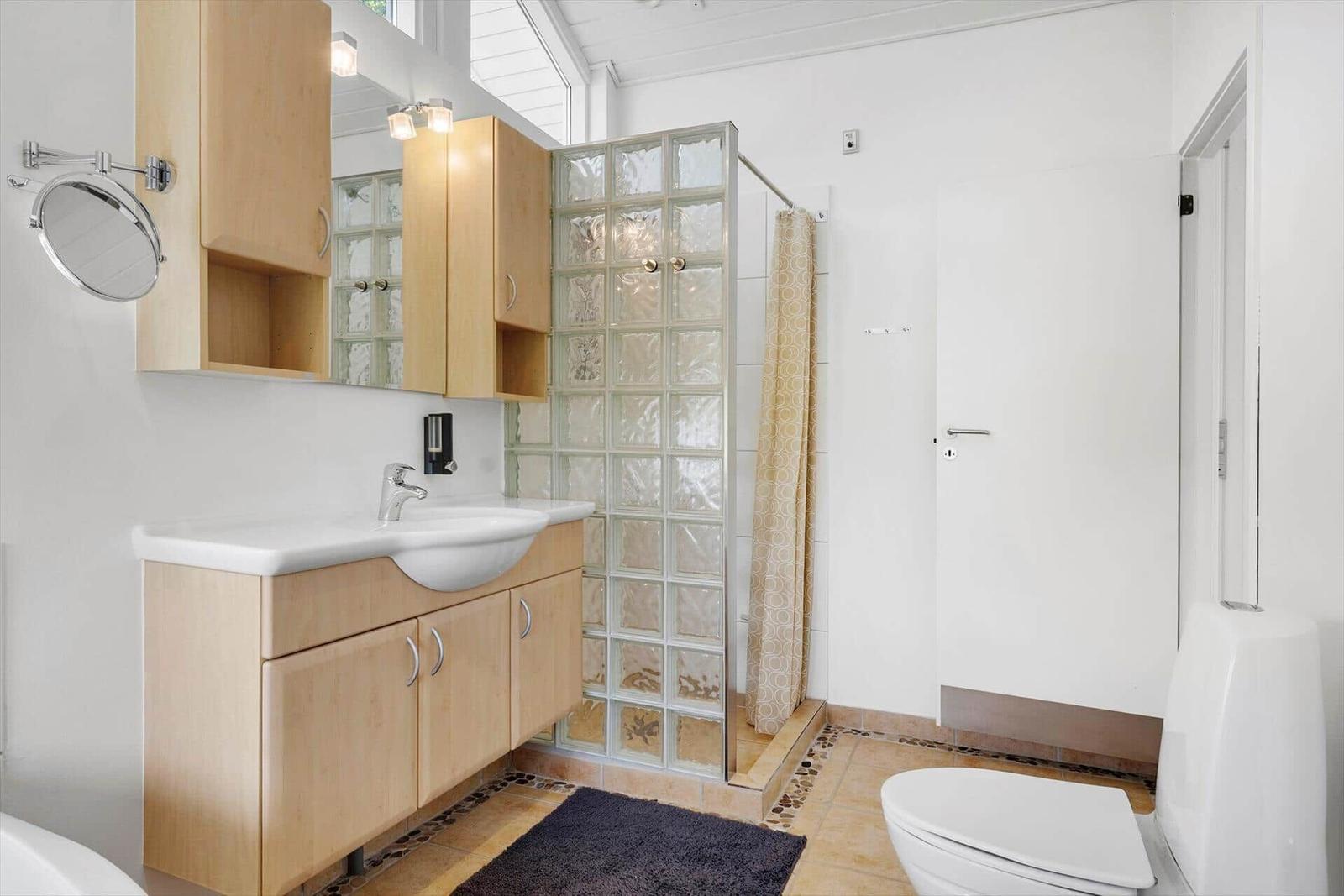 Badezimmer mit Waschbecken, Dusche und Toilette.