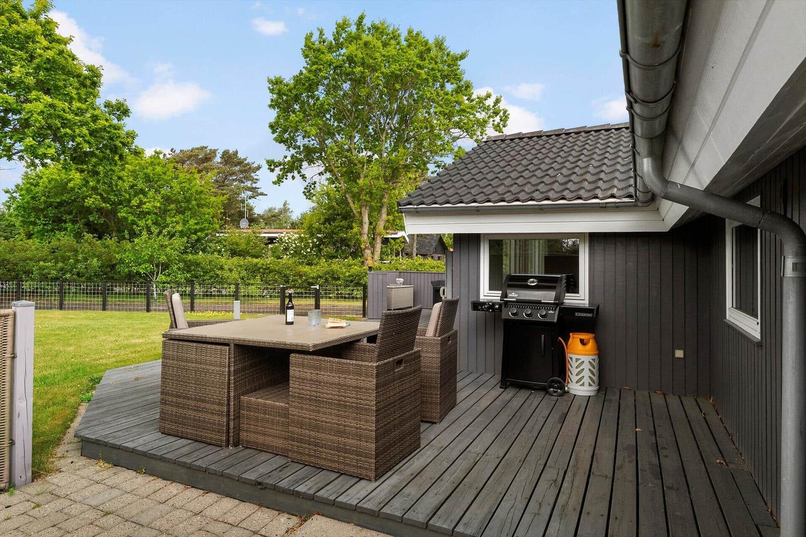 Terrasse mit Grill und Sitzgruppe im Freien.