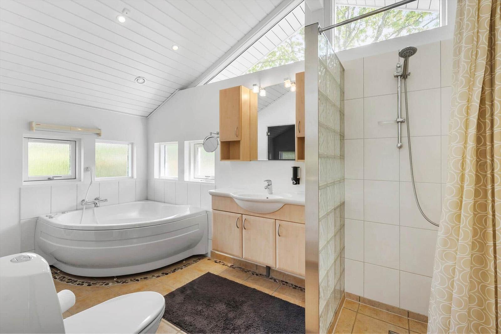 Badezimmer mit Badewanne, Dusche und Waschbecken.