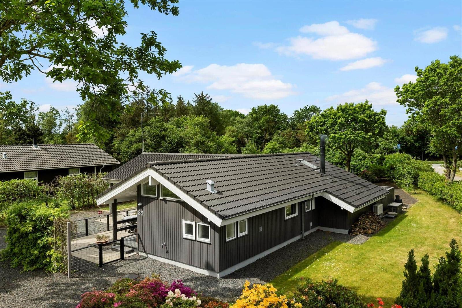 Moderne Ferienhaus mit Garten und Terrasse in grüner Umgebung.