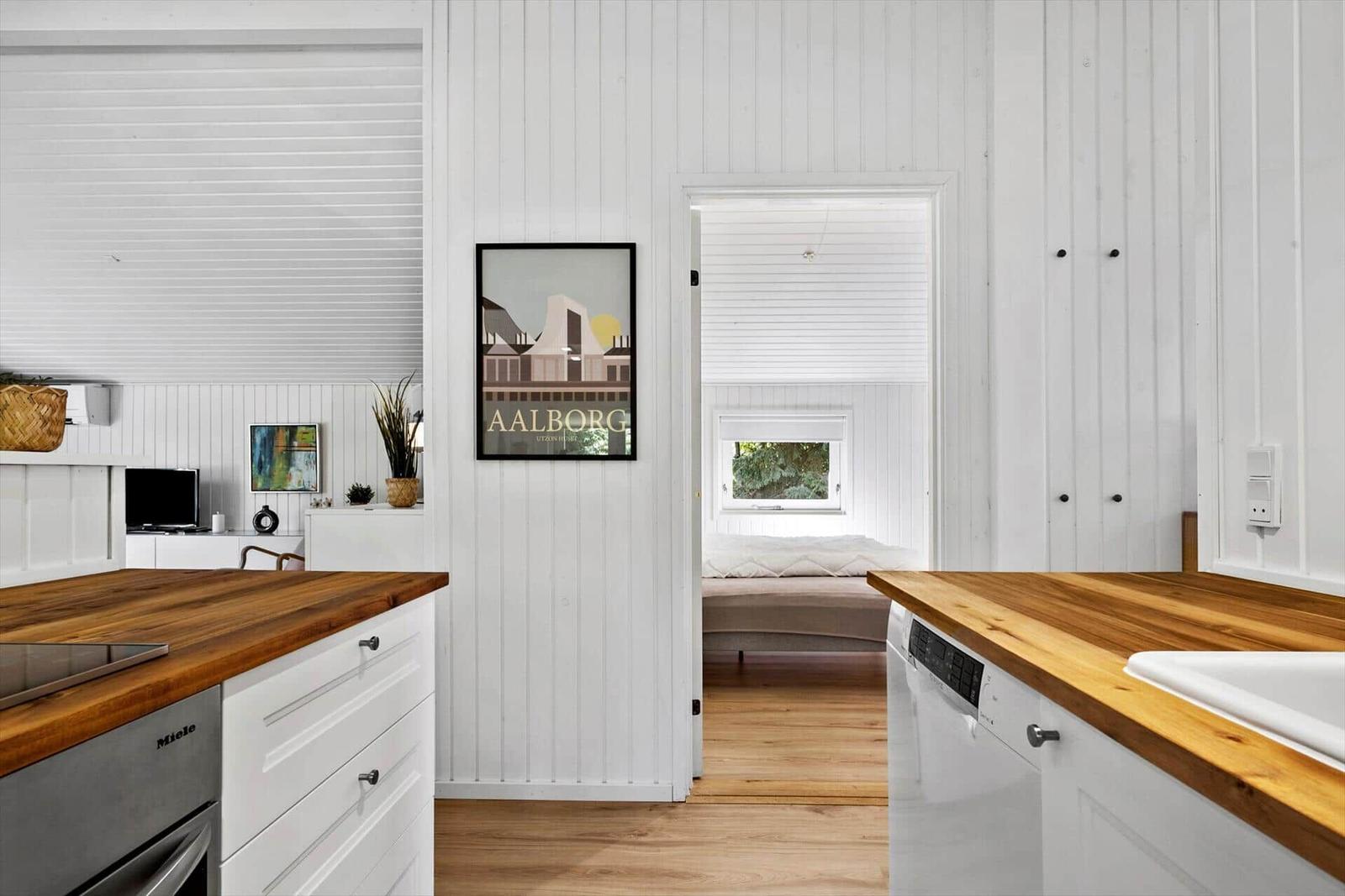 Küche mit Holz Arbeitsplatten und Blick in Schlafzimmer mit Fenster