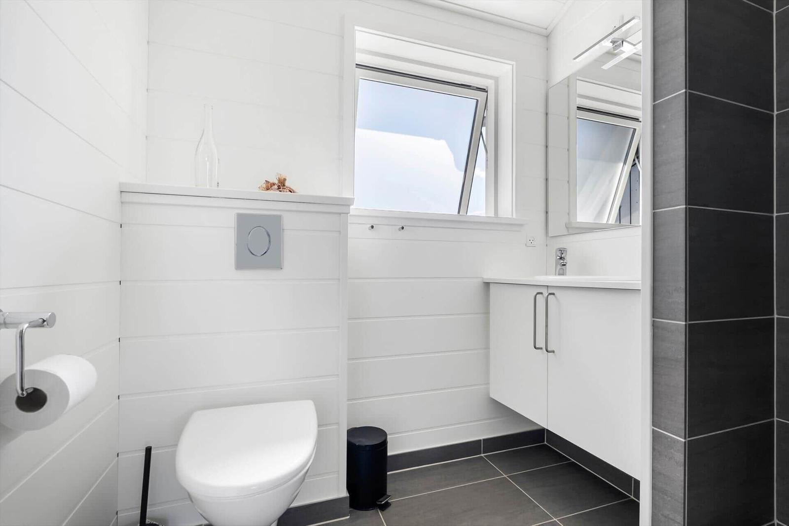 Badezimmer mit Toilette, Waschbecken und Fenster