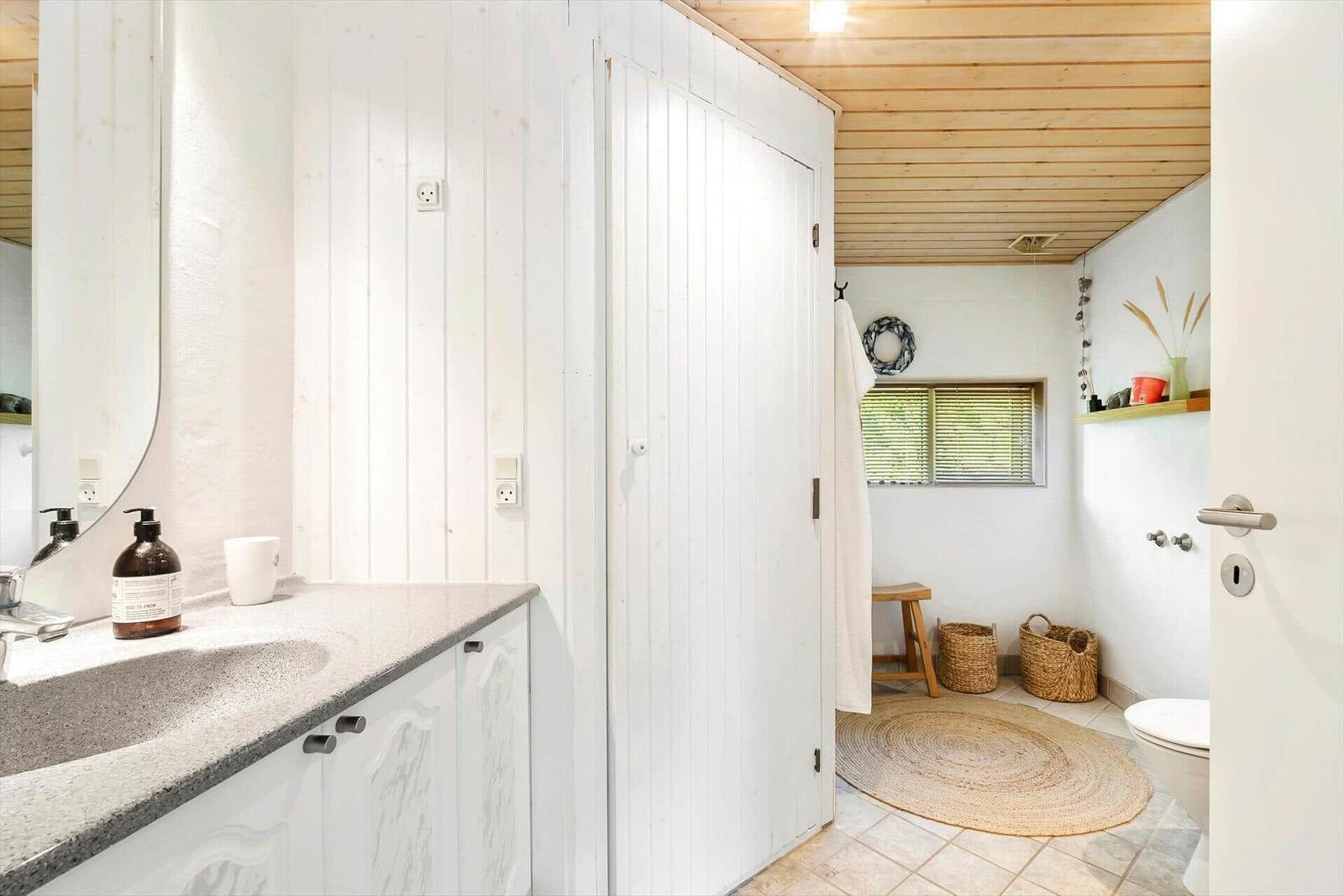 Badezimmer mit Waschtisch, Spiegel, Toilette und Dusche