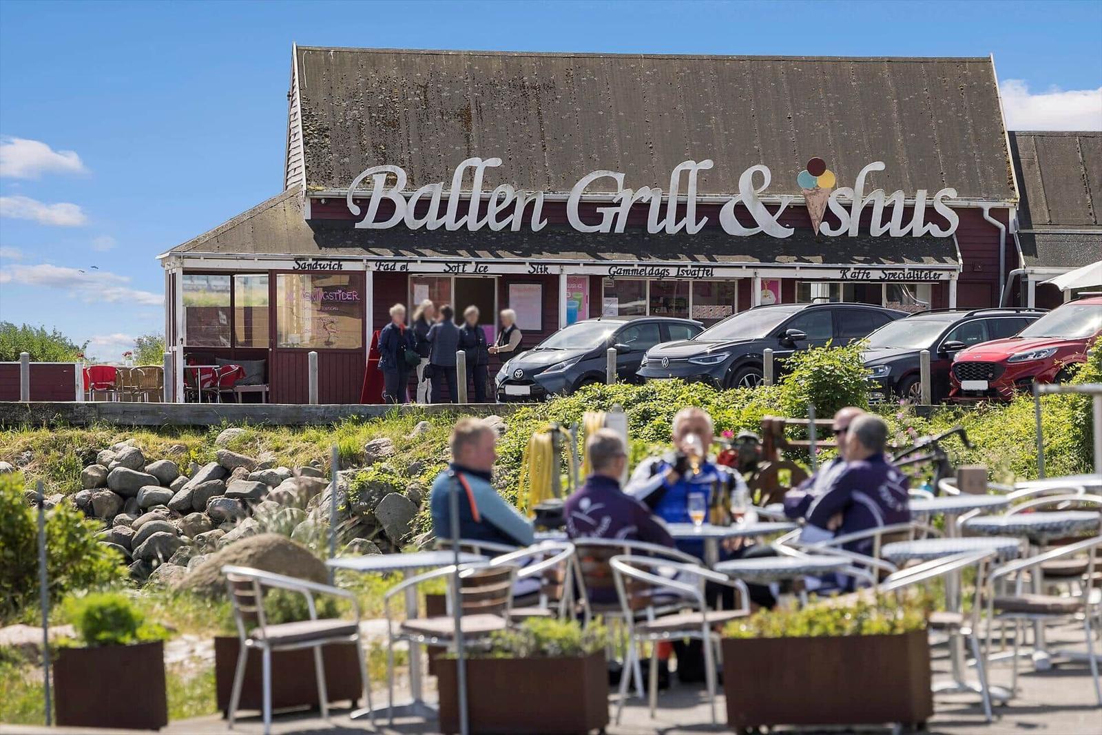 Außenbereich mit Tischen und Stühlen vor einem Restaurant.
