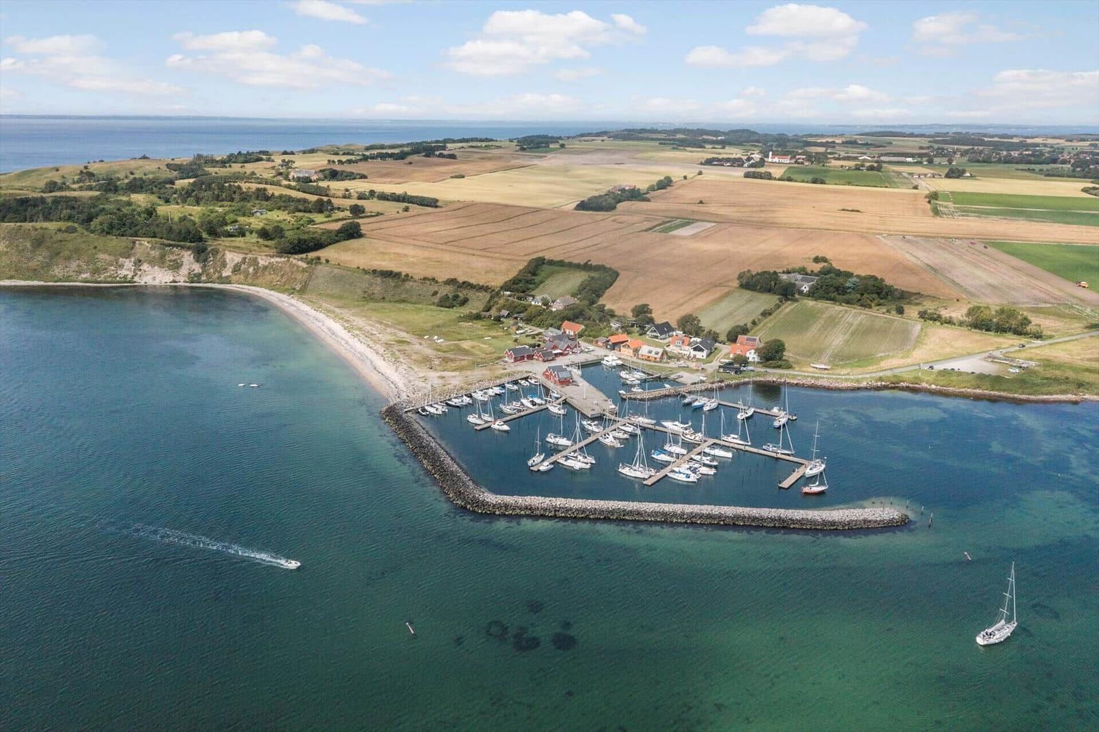Hafen mit Booten, Strand und umliegenden Feldern.