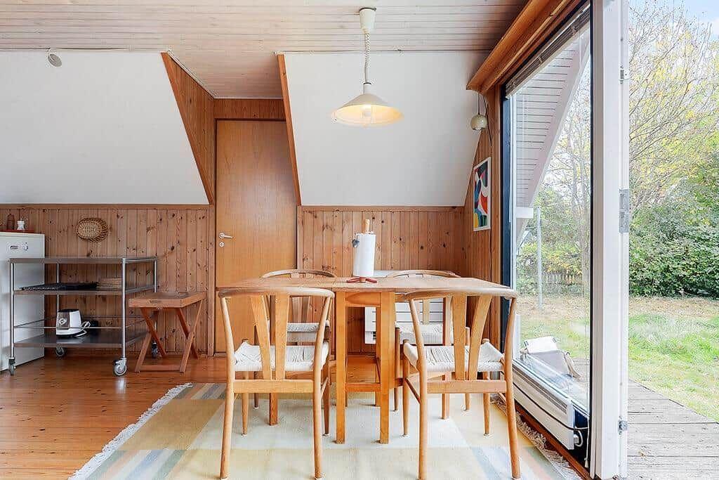 Essbereich mit Holztisch und Stühlen, große Glasfront zum Garten