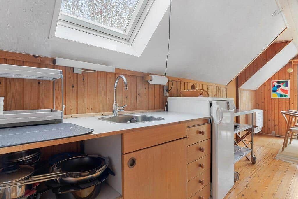 Küche mit Dachschräge, Holzwand und Fenster