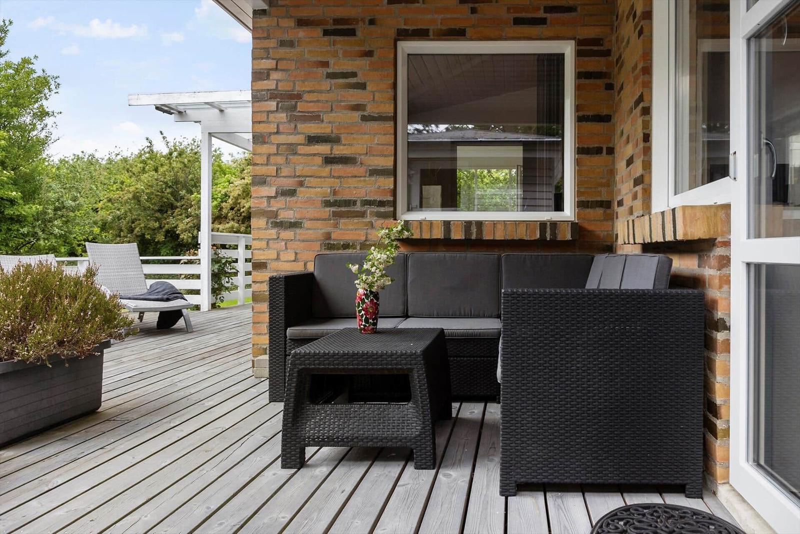 Deck with seating group, plants, and view into the garden.