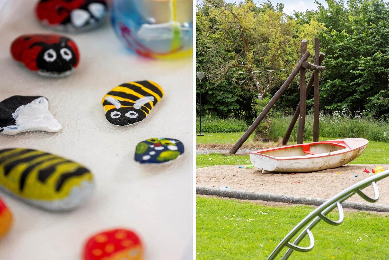Painted stones and playground with boat and climbing frame in the garden.