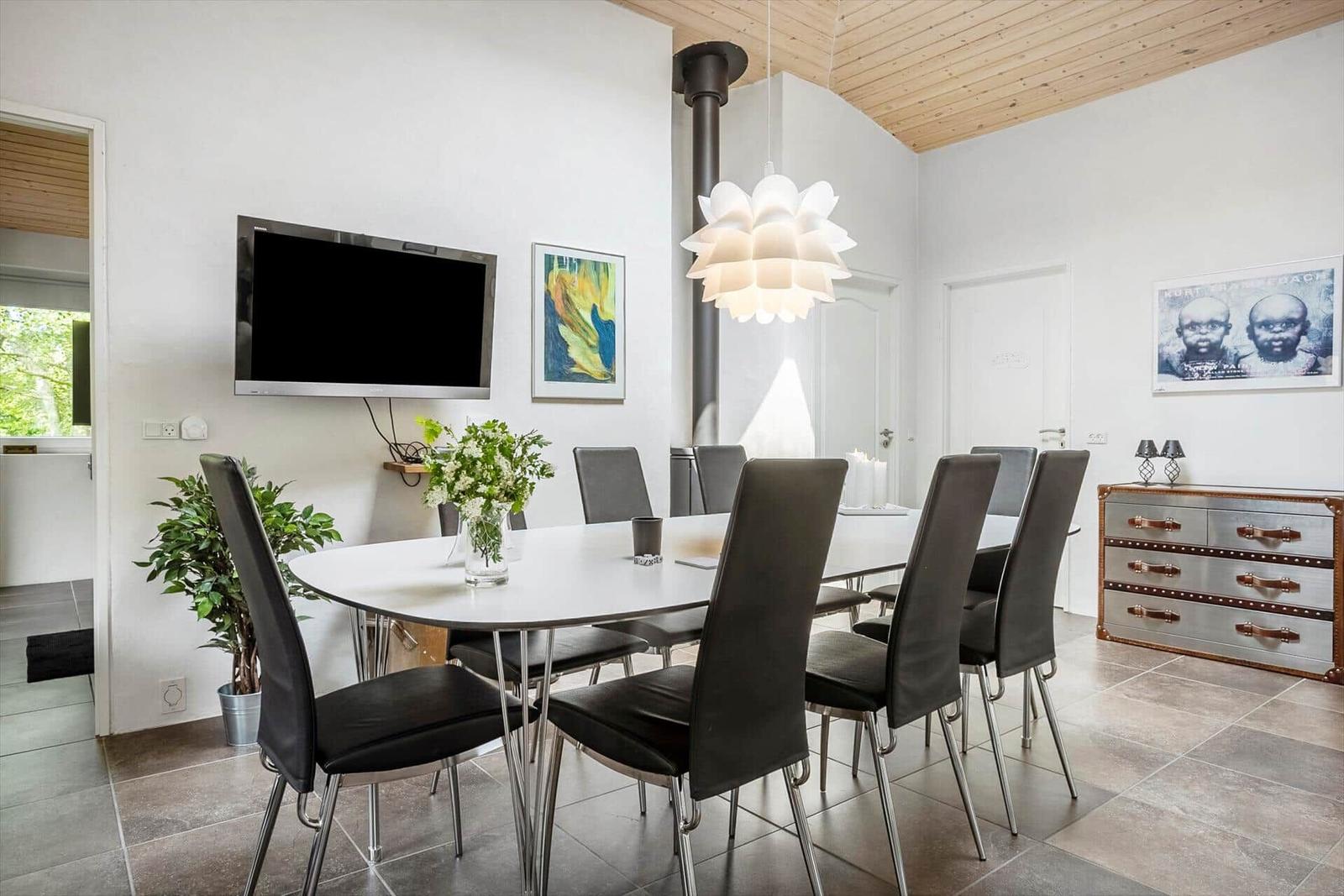 Dining room with round table, black chairs, and ceiling fan.