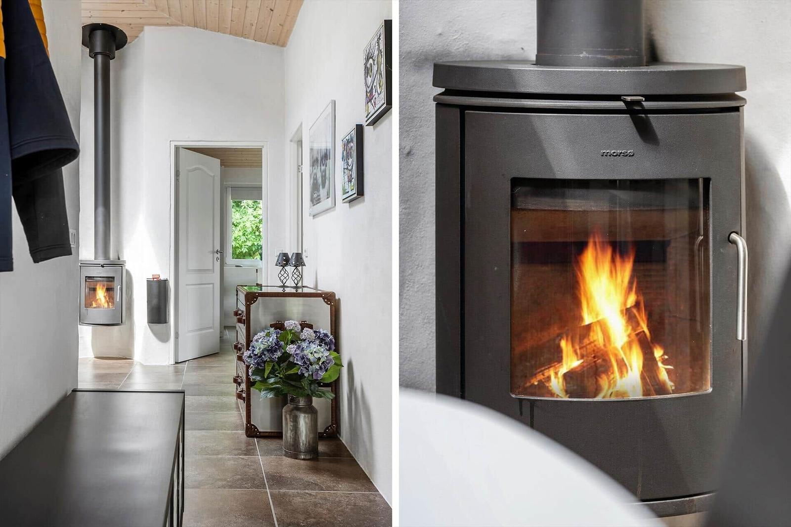 Hallway with wooden ceiling and wood-burning stove. Close-up of the burning stove.