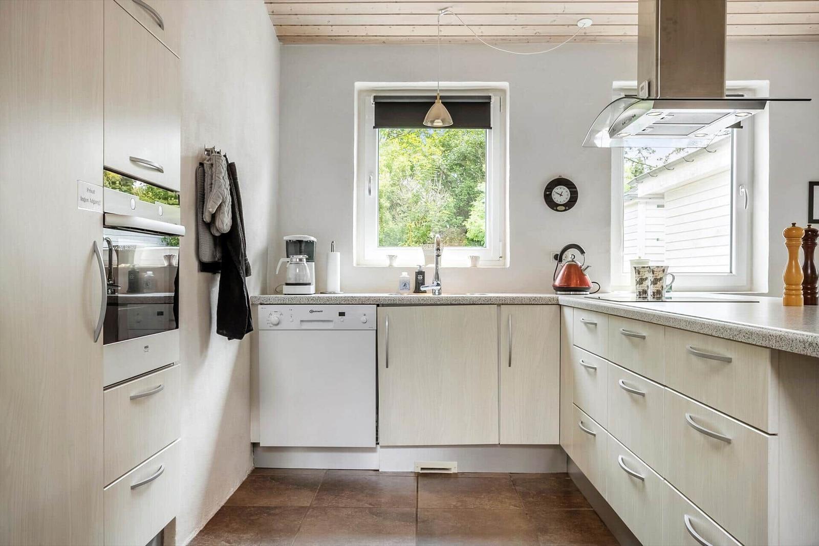 Kitchen with light cabinets, sink, window, and kitchen counter.