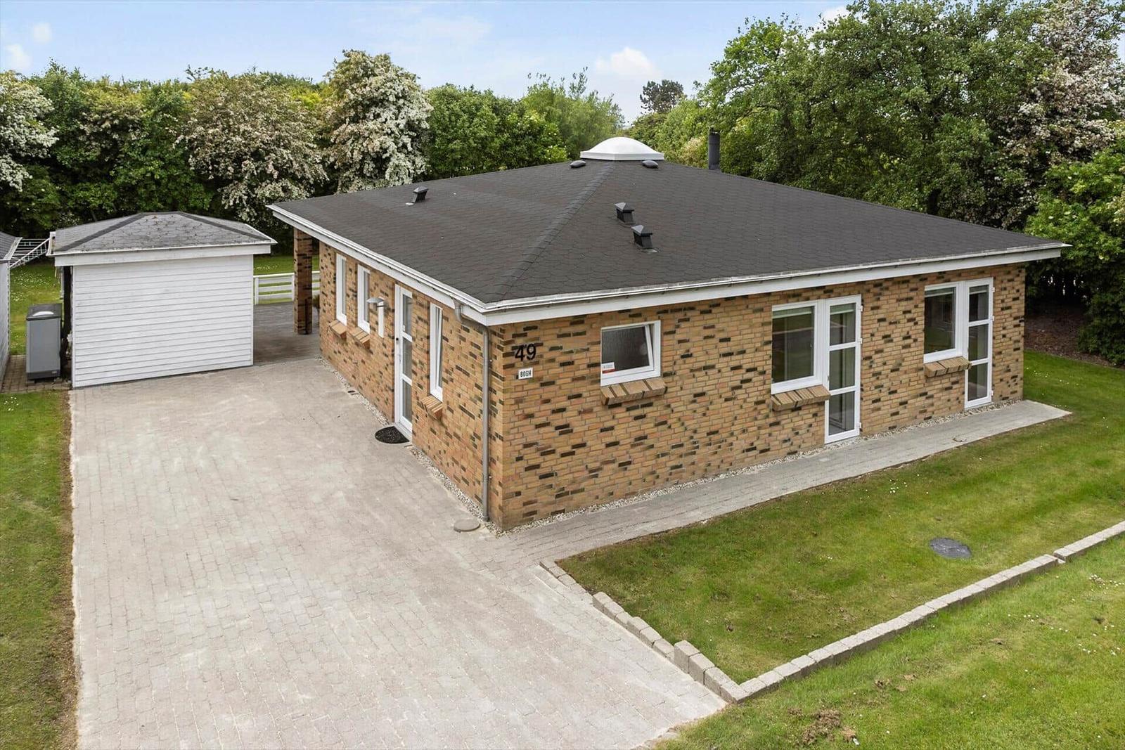 Single-story house with brick facade, garage, and lawn area.