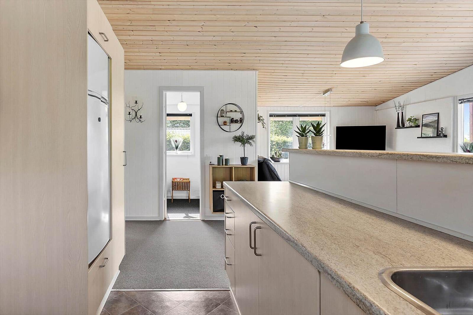 Kitchen with countertop, refrigerator, and view into living area.