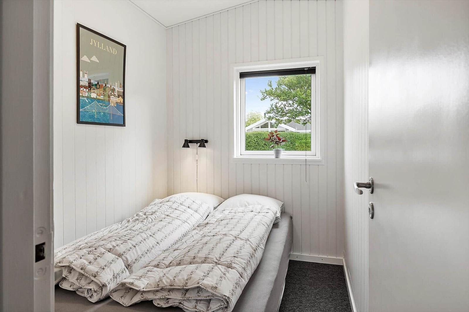 Bedroom with bed, window, and wall art.