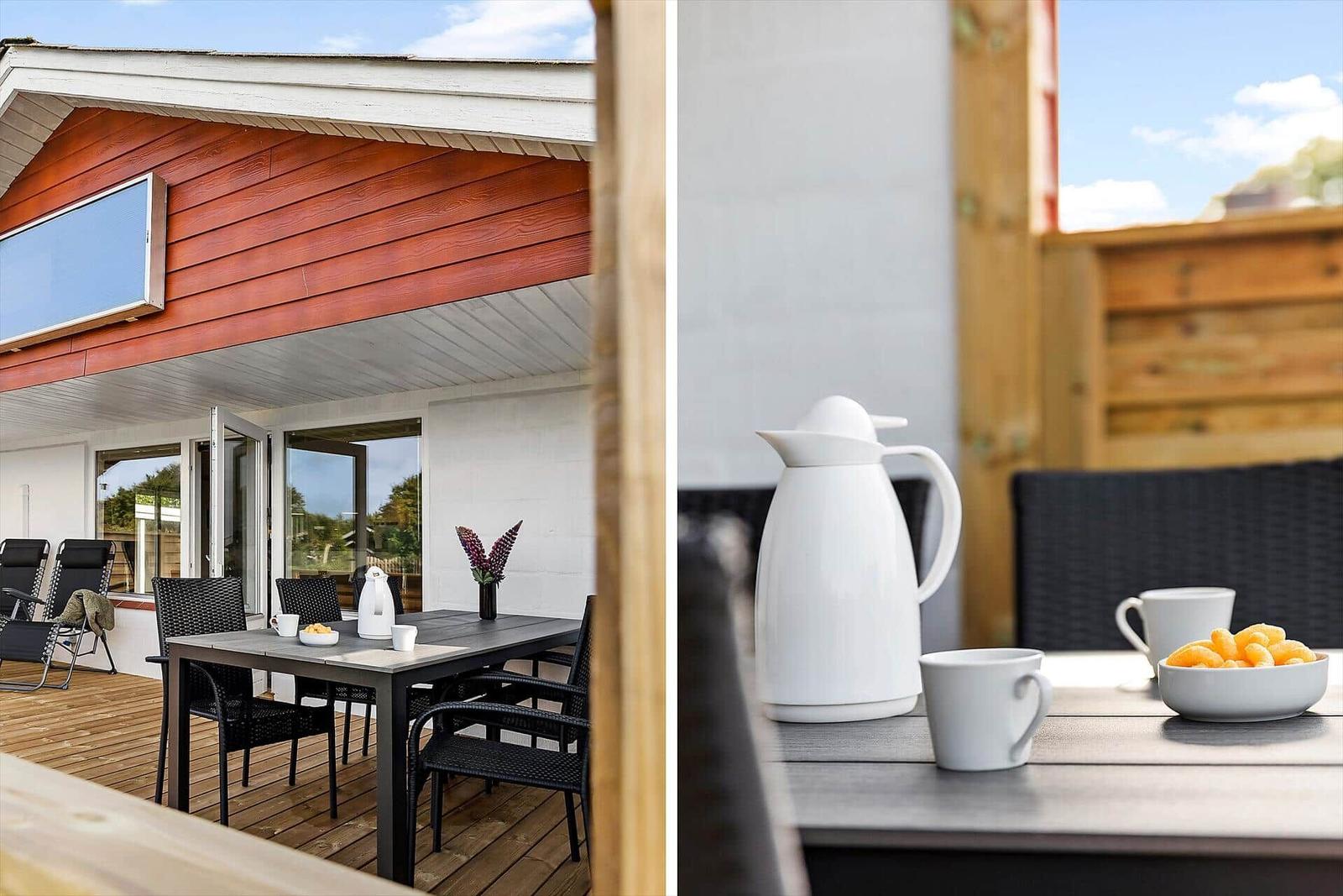 Terrace with table, chairs, and outdoor shower. Table with thermos and cups.