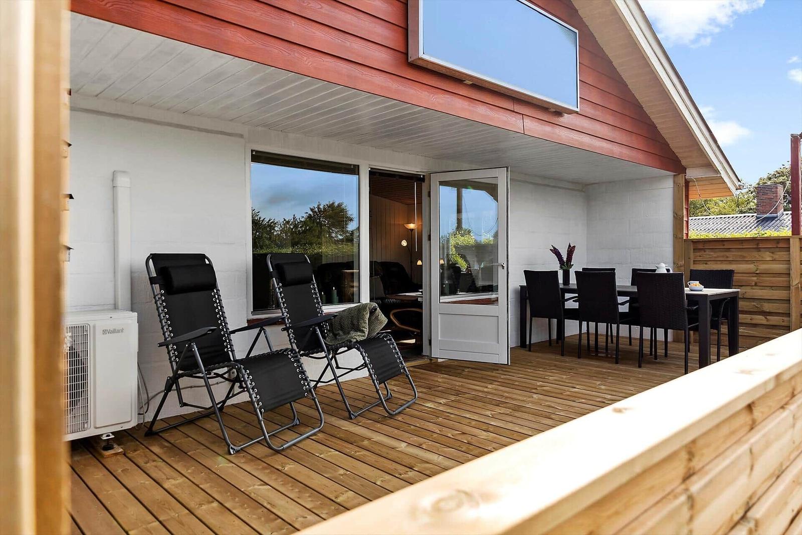 Deck with seating and dining area under roof.