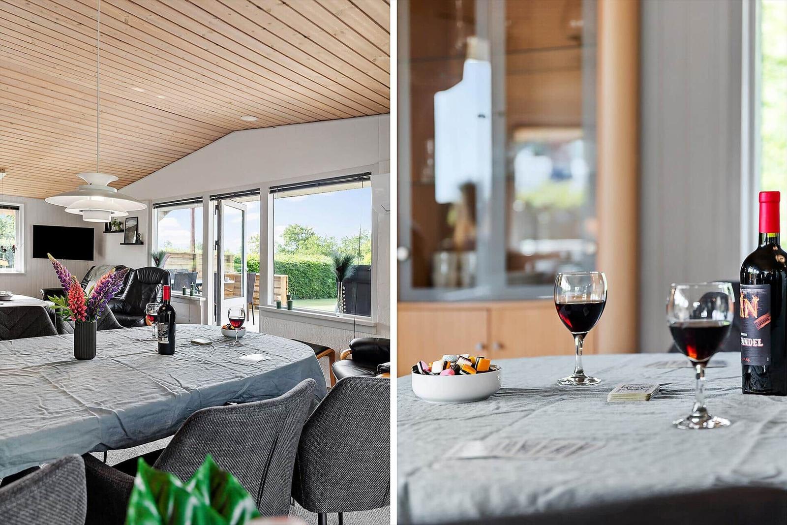 Dining room with table, chairs, and windows to the garden. On the table are two wine glasses and a bottle.