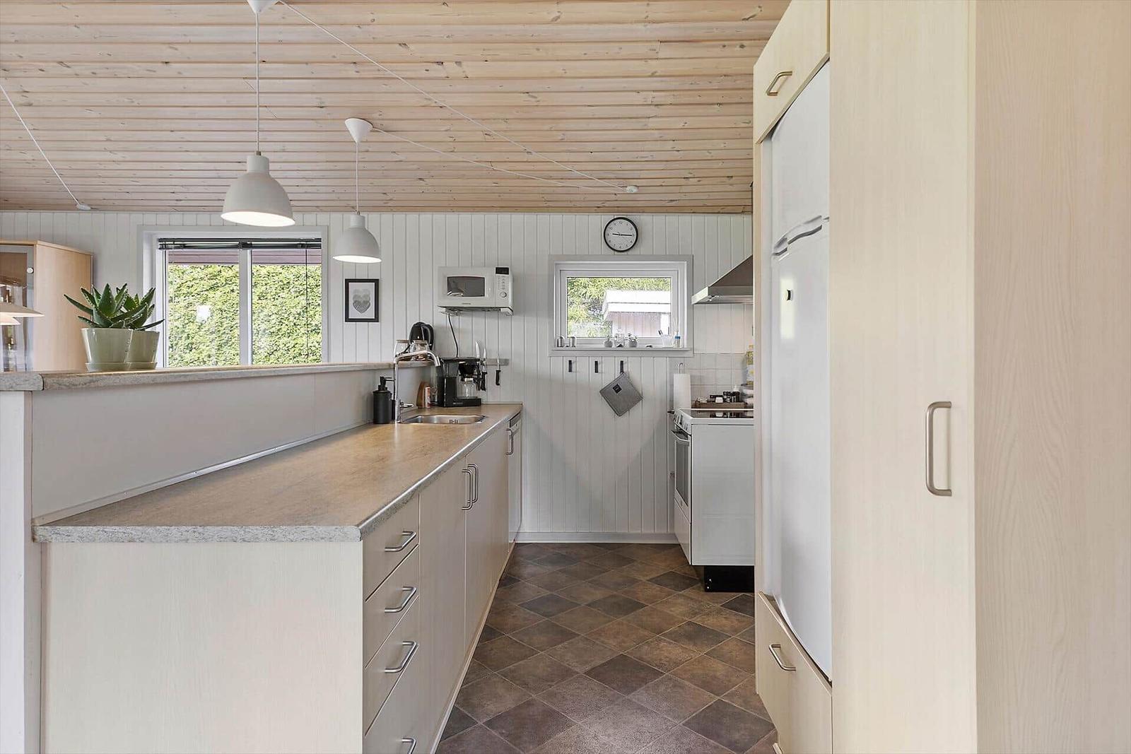 Kitchen with wooden ceiling, countertop, and appliances