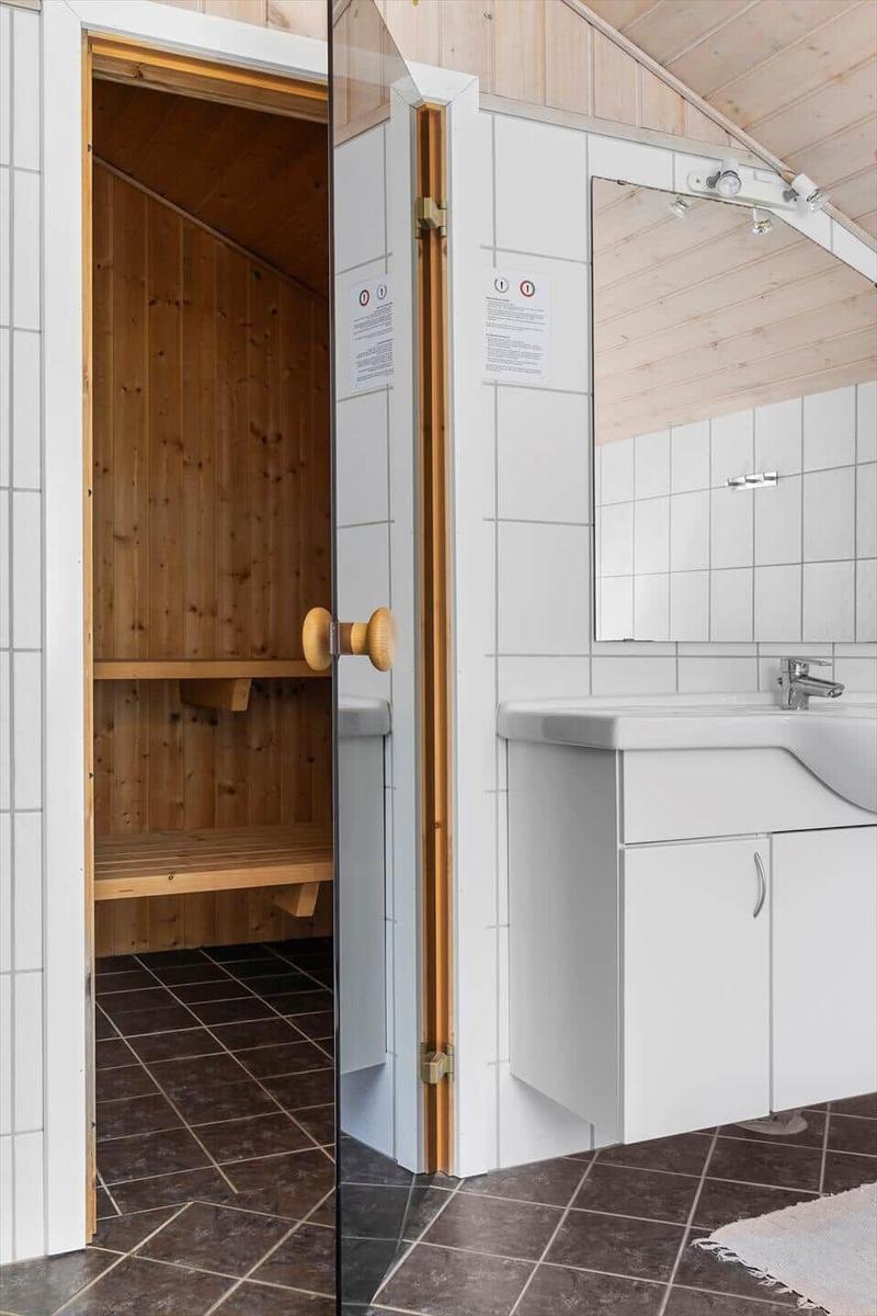 Dusche mit Holzsauna, Waschbecken und Spiegel
