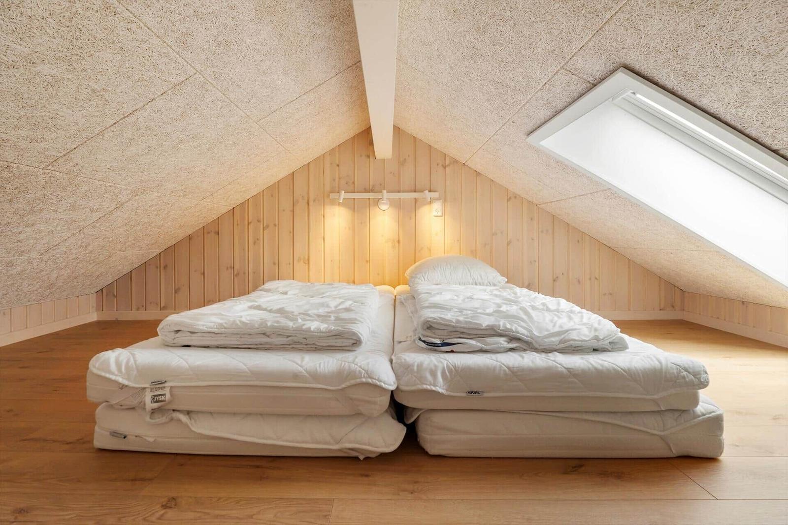 Zwei Matratzen mit Bettwäsche stehen im Dachgeschosszimmer.