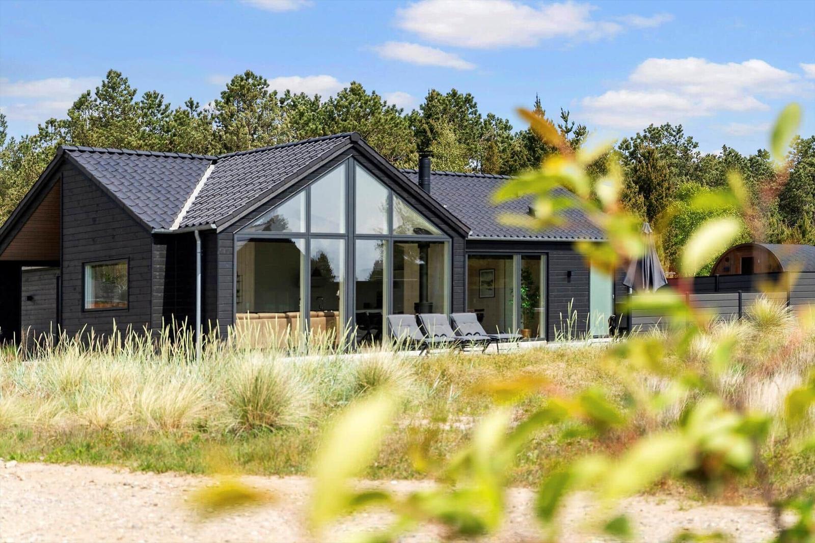 Moderne Villa mit großem Glasbereich und Außenterrasse im Wald