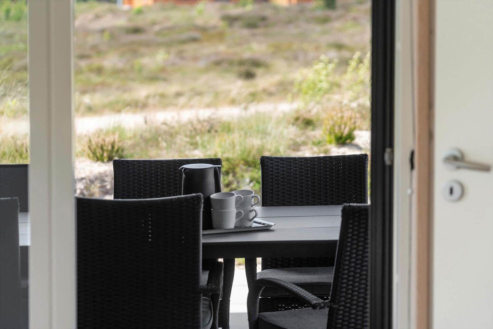 Terrasse mit Tisch und Stühlen, Blick auf Grünflächen