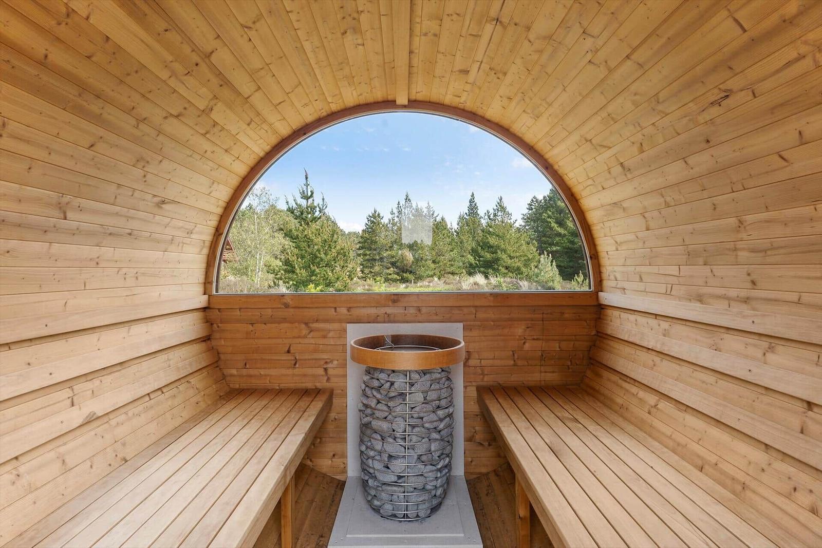 Holzsauna mit runder Aussichtsfenster und Steinofen