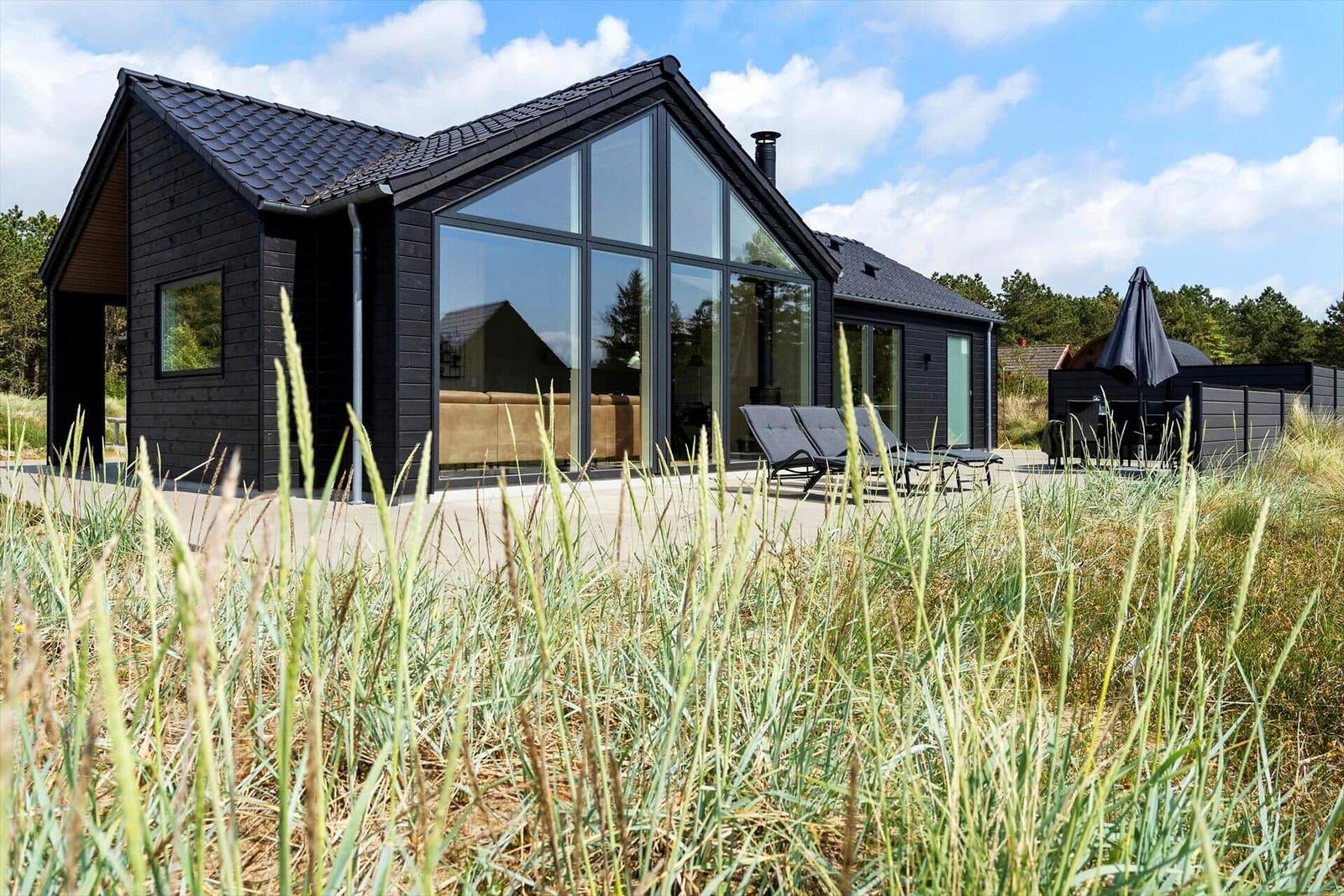Moderne Villa mit großem Glasbereich und Terrasse im Grasland.