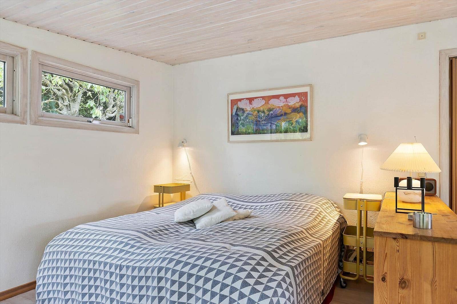 Bedroom with bed, window, and wall art.