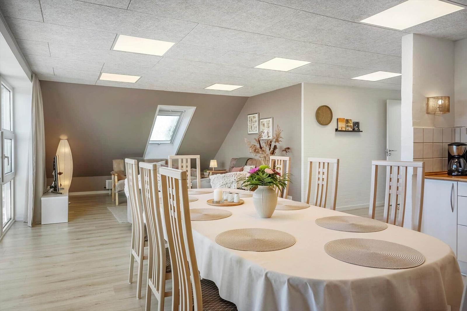 Dining room with table, chairs, and view into living area