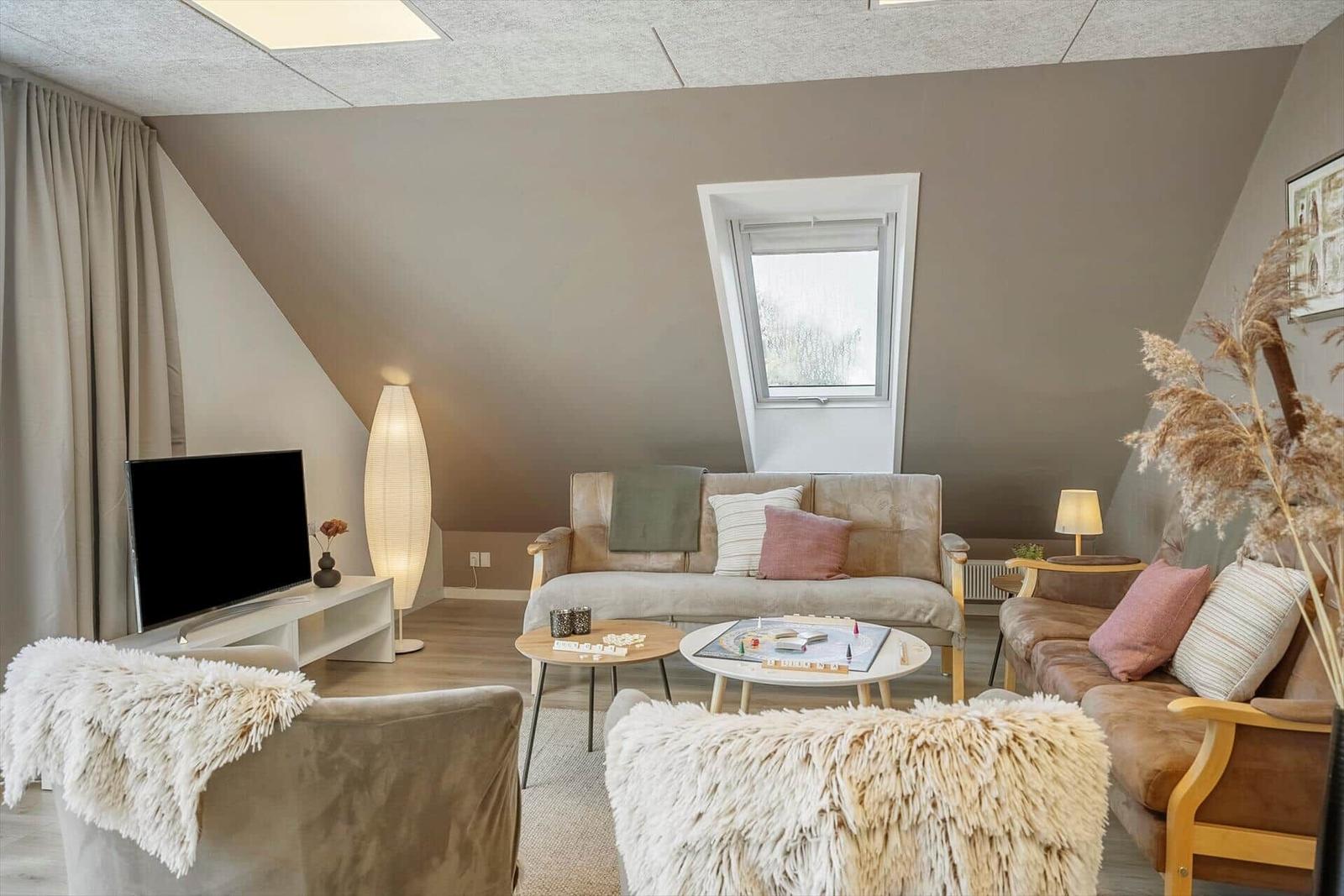 Living room with sofa, chairs, TV, and window
