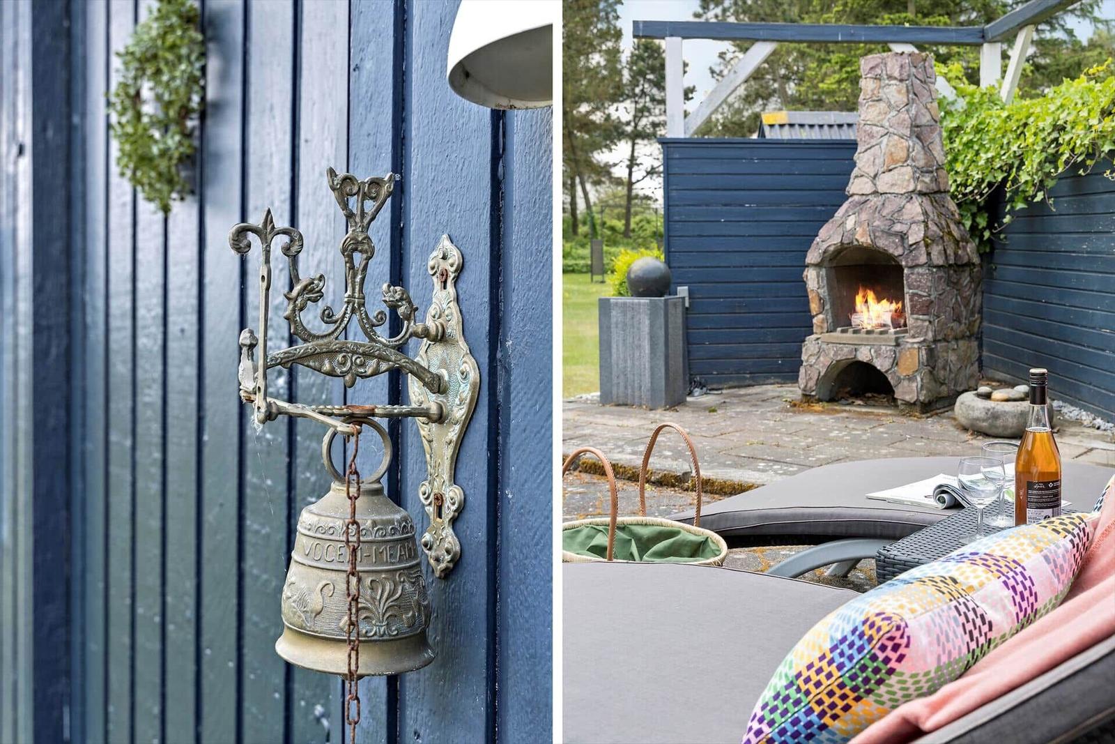 Vintage bell on blue wall and stone fireplace in garden with lounge and bottle.