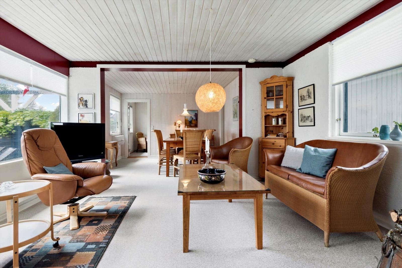 Living and dining area with brown leather and wooden furniture.