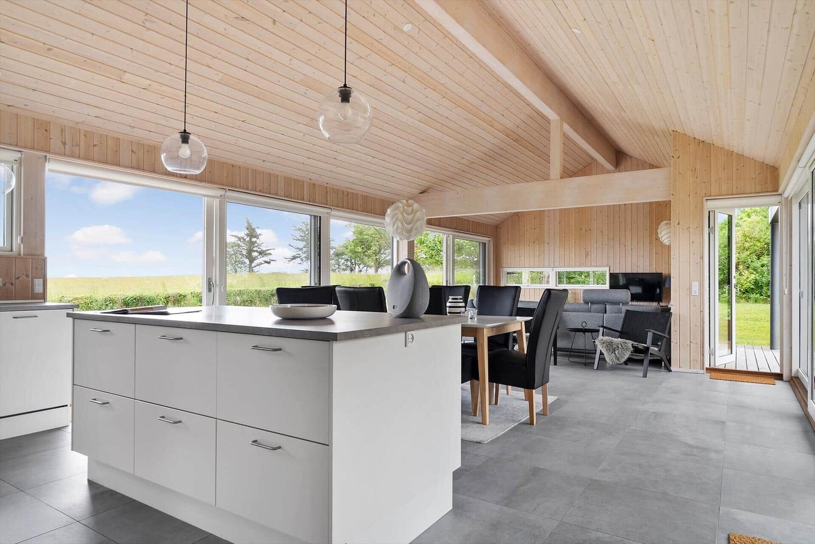 Moderne Küche mit Essbereich und Wohnzimmer mit Holzdecke und großzügigen Fenstern.