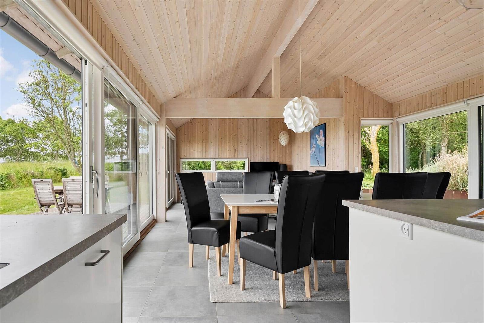 Essbereich mit Tisch, Stühlen und großem Fensterblick auf Garten