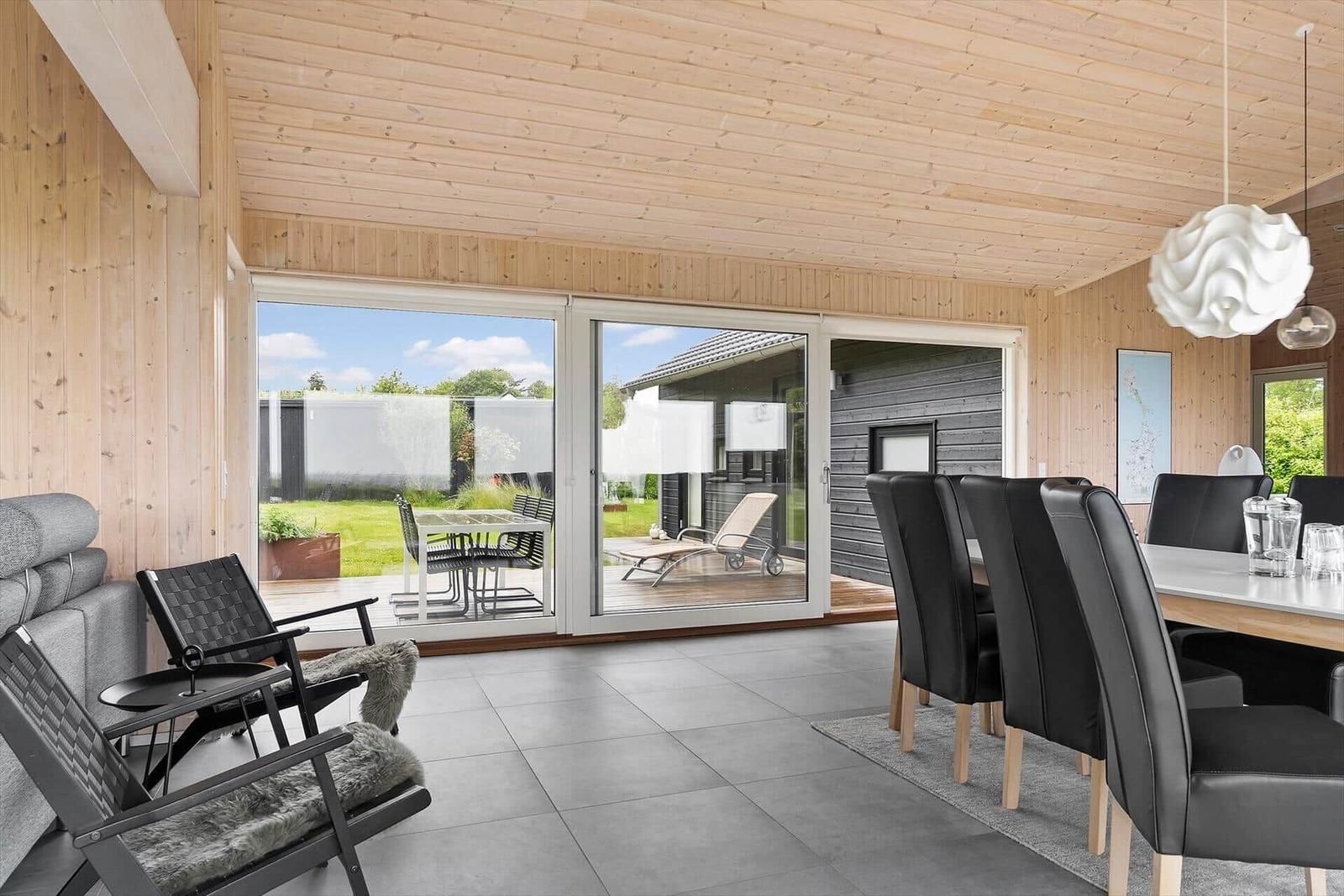 Großer Raum mit Essbereich, Sitzgelegenheiten und Blick auf die Terrasse.