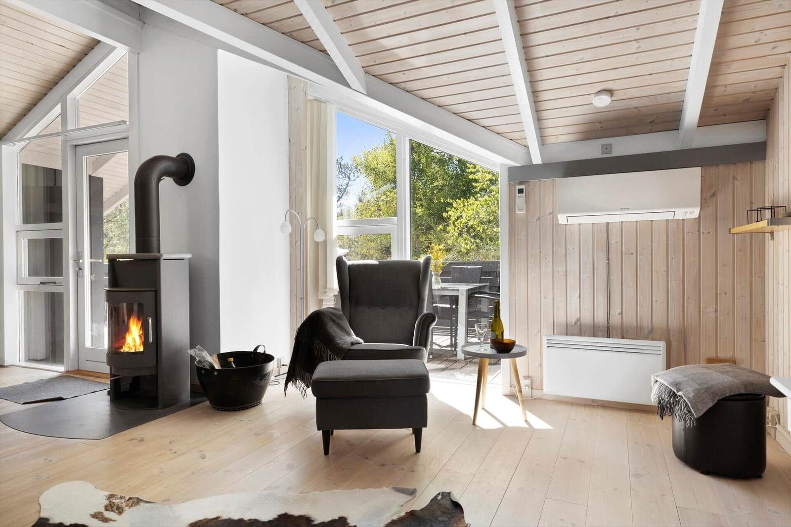Living room with fireplace, armchair, and garden view