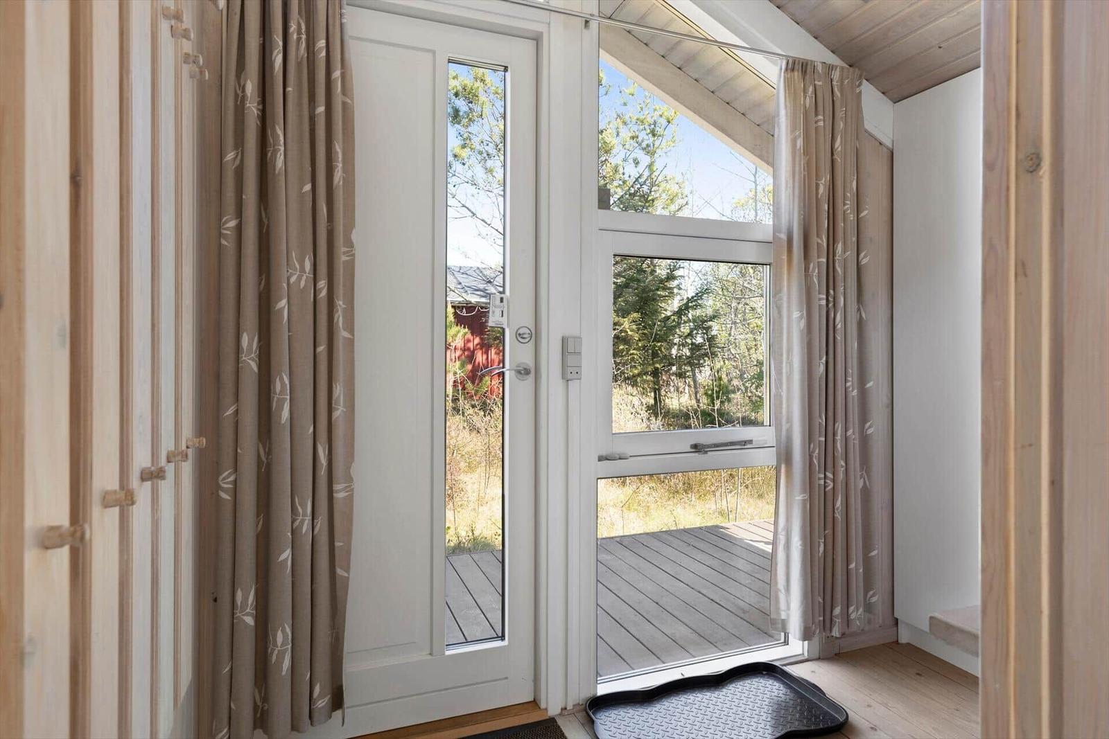 Bright entrance door with view of terrace and forest.