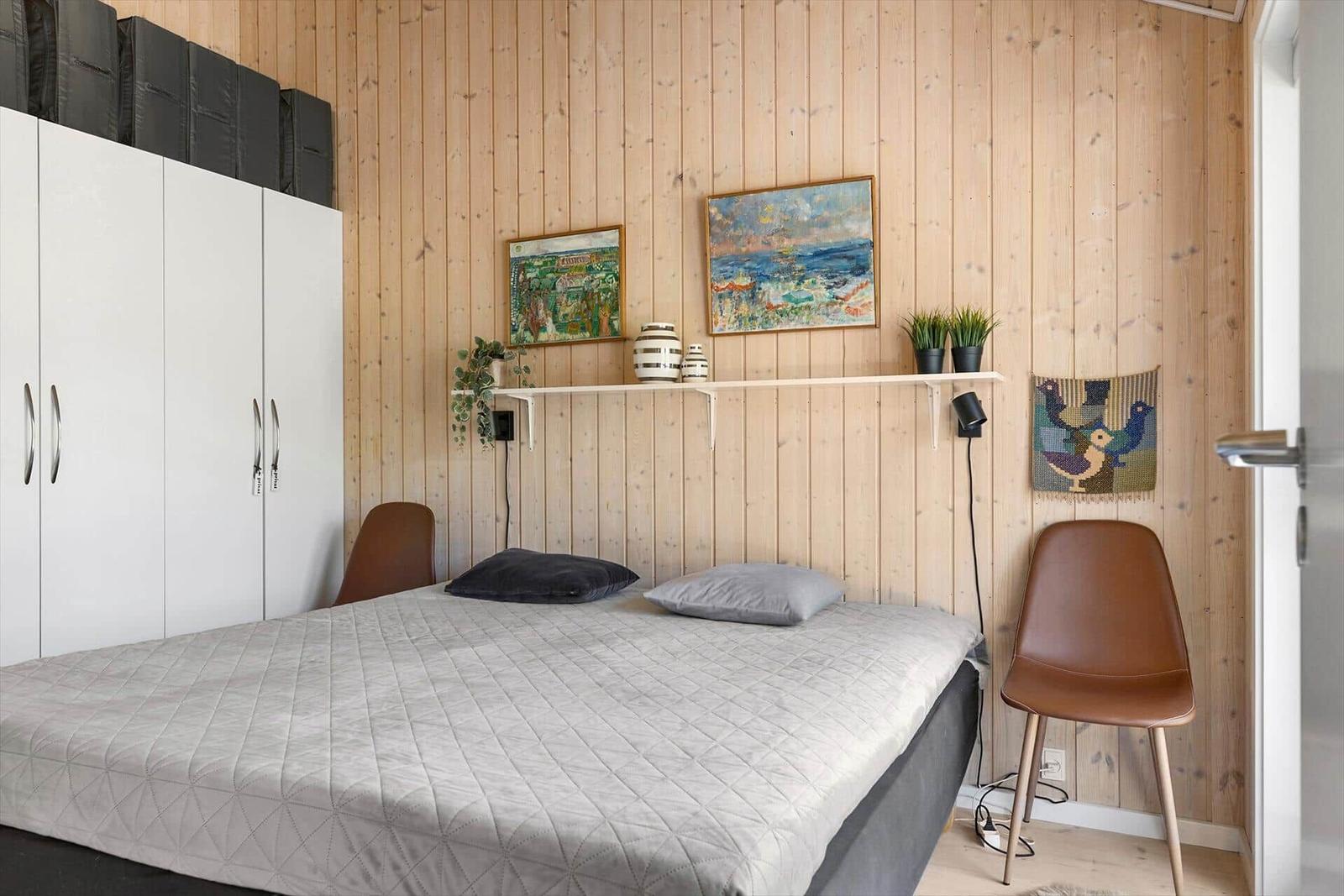 Bedroom with bed, wardrobe, and wall decor.