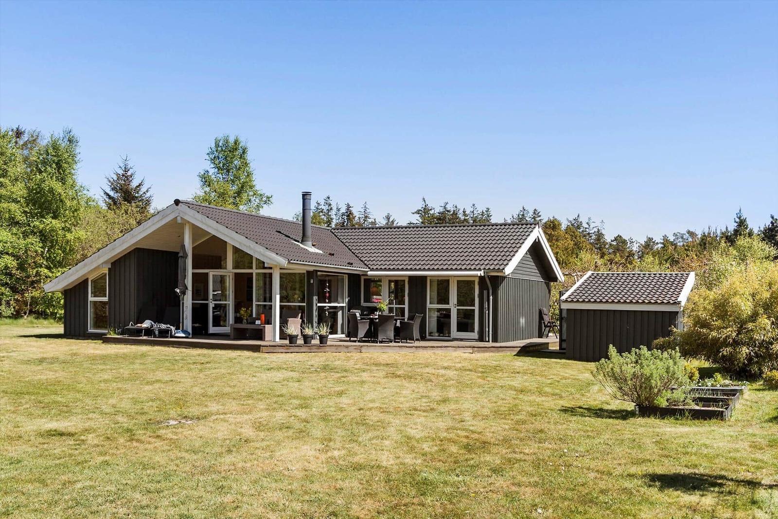 A house with terrace, garden and outdoor grill area.
