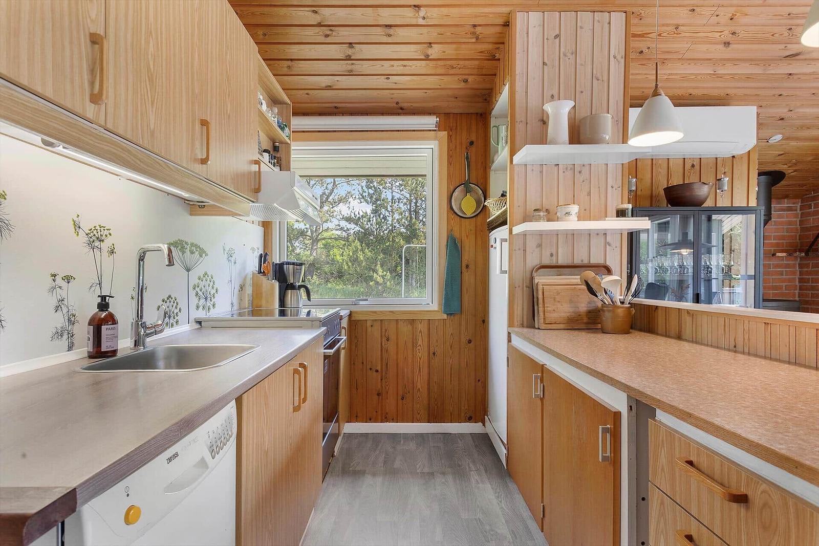Kitchen with wooden elements, window, and work surfaces