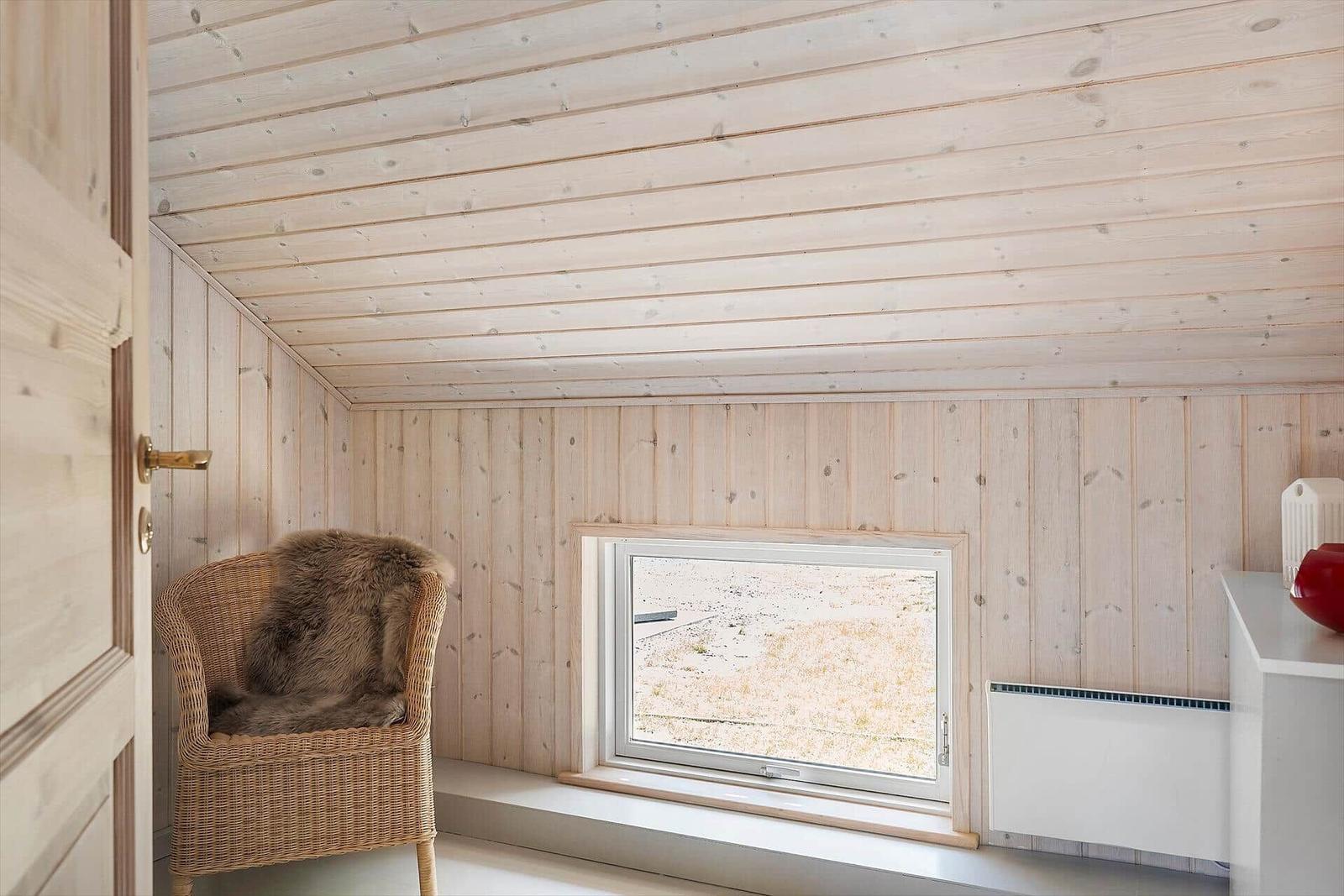 Raum mit Holzwand und -decke, Sitzgelegenheit, Fenster und Heizkörper