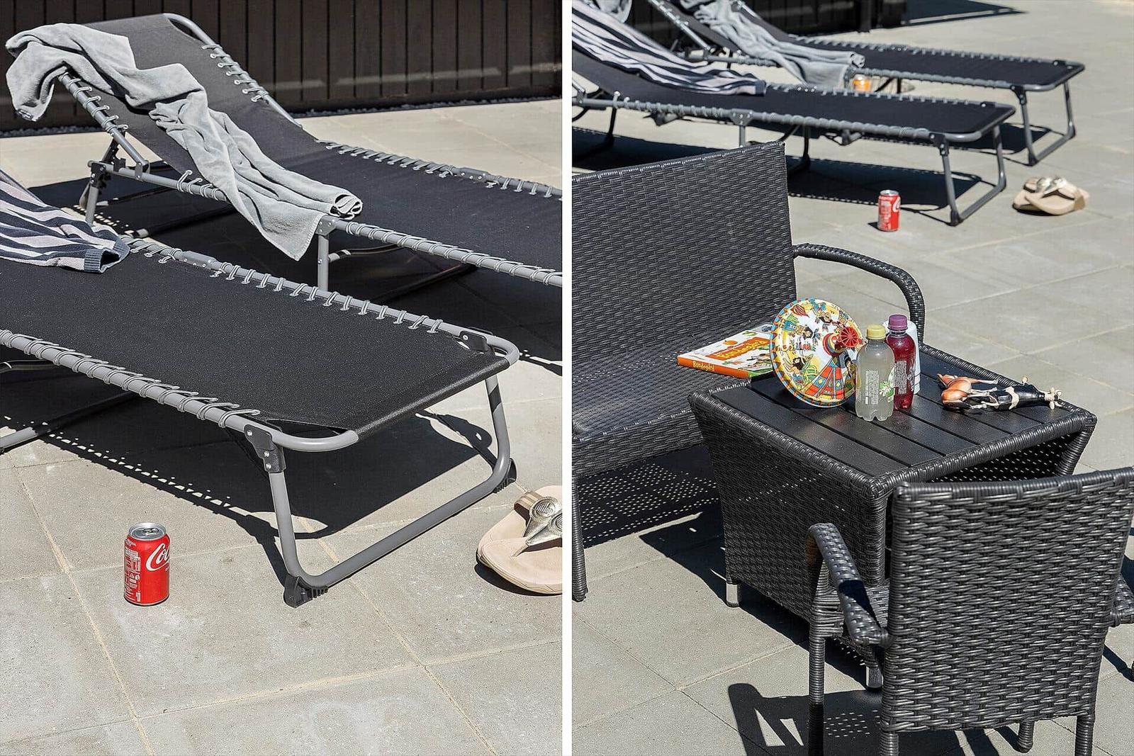 Terrasse mit Liegestühlen und Tisch. Getränke und ein Buch darauf.